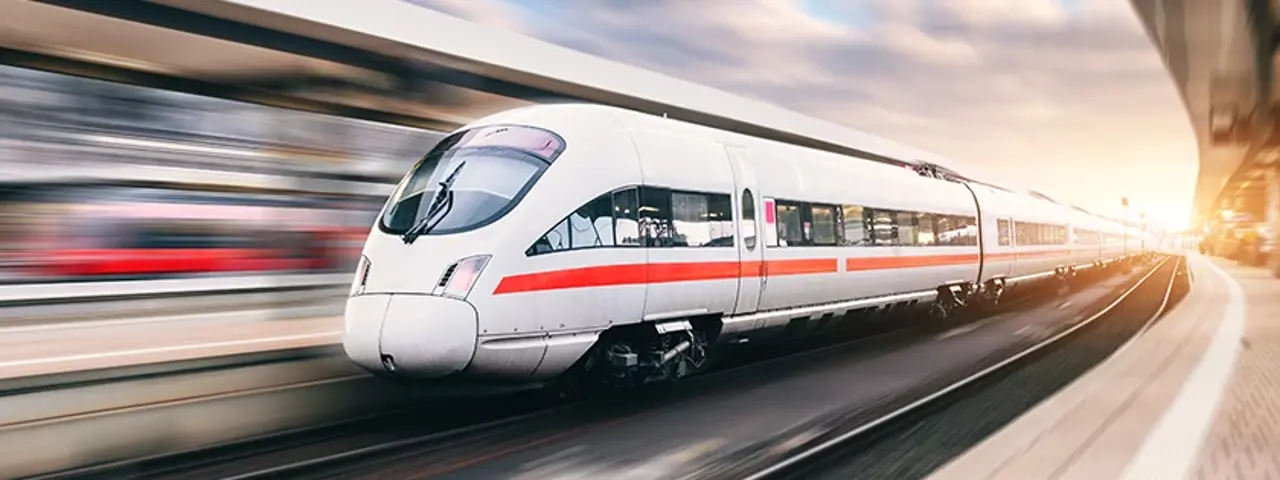 White and red train moving through station nexy to platform